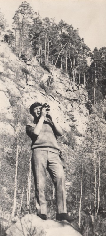 Фотографія. В. Івасюк стоїть на камені, у руках біля обличчя тримає кінокамеру. 1969 рік.