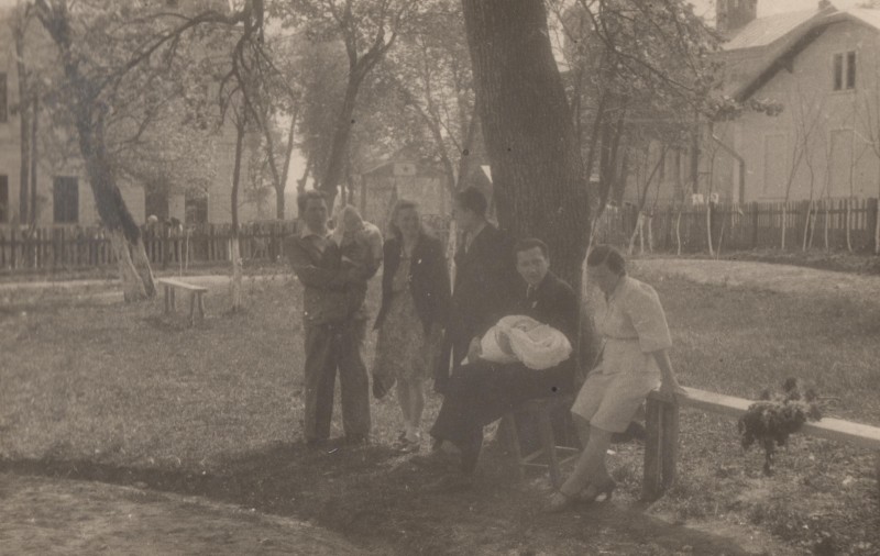 Фотографія. М. Івасюк сидить на табуретці, на руках маленький Володя. Позаду видно паркан. Кіцмань. 1 травня 1949 року.