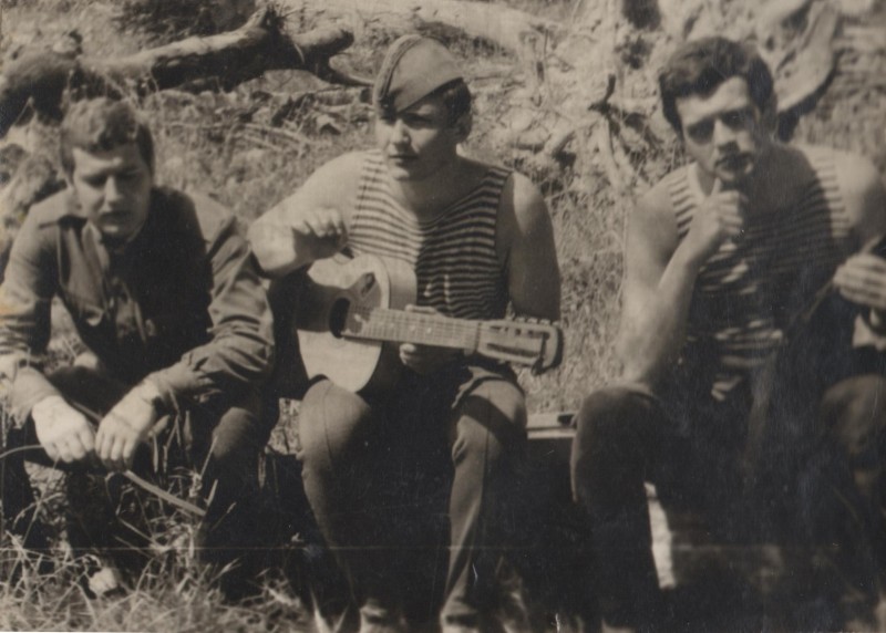 Фотографія. В. Івасюк сидить на бревні з двома хлопцями і грає на гітарі. Новоград-Волинський. Липень 1972 року.