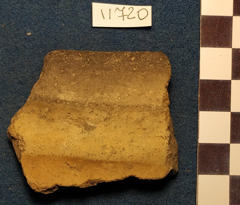 Фрагмент вінець  ліпної сіроглиняної посудини жовтого кольору ззовні