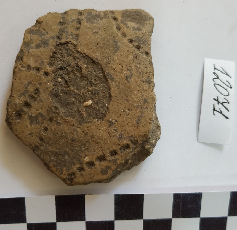 Фрагмент стінки ліпної сіроглиняної посудини жовтого кольору ззовні