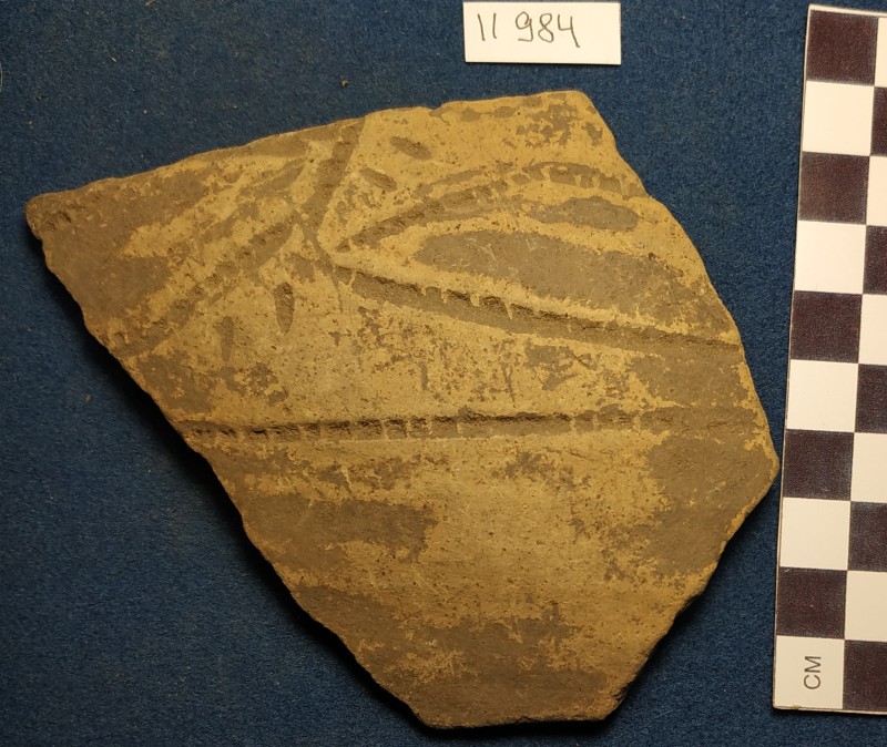 Фрагмент стінки ліпної сіроглиняної посудини жовтого кольору ззовні