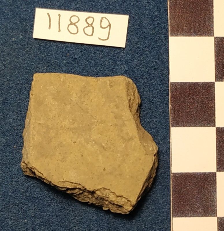 Фрагмент стінки ліпної сіроглиняної посудини жовтого кольору ззовні