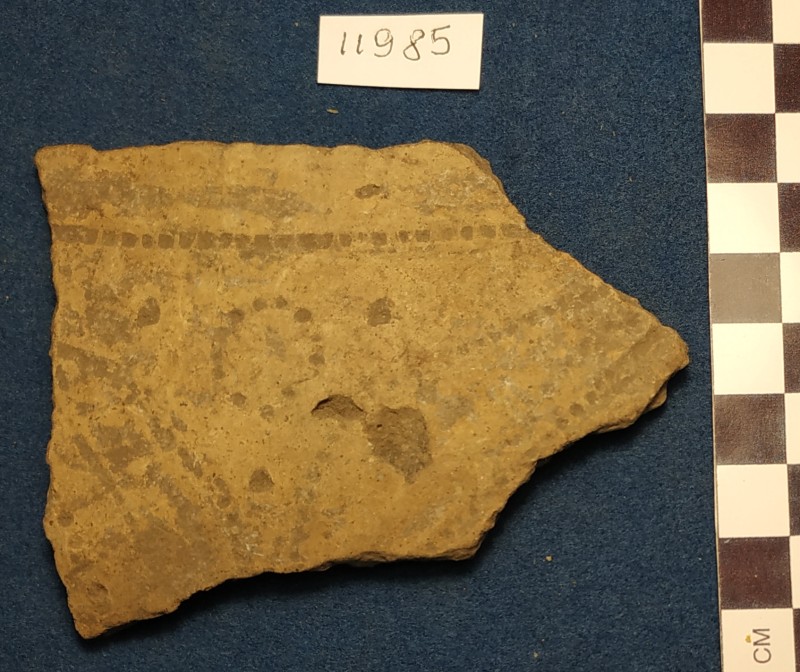 Фрагмент стінки ліпної сіроглиняної посудини жовтого кольору ззовні