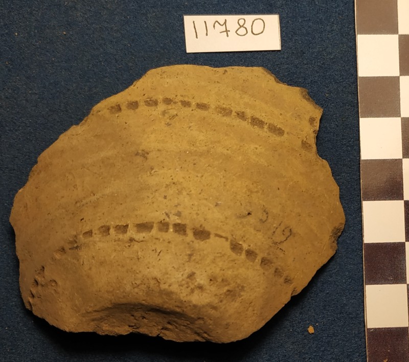 Фрагмент дна і придонної частини ліпної сіроглиняної посудини жовтого кольору ззовні із лощеною поверхнею