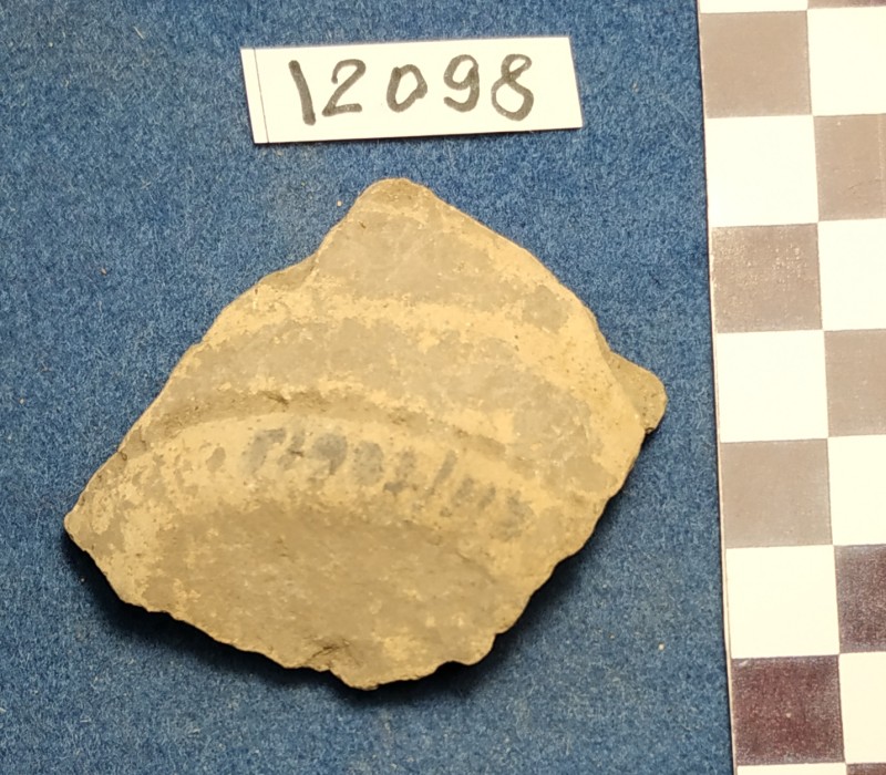 Фрагмент дна і придонної частини сіроглиняної посудини жовтого кольору ззовні