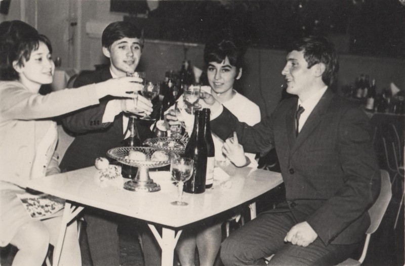 Фотографія. В. Івасюк сидить за столиком із друзями з келихами шампанського. 1968 рік (Новий рік).