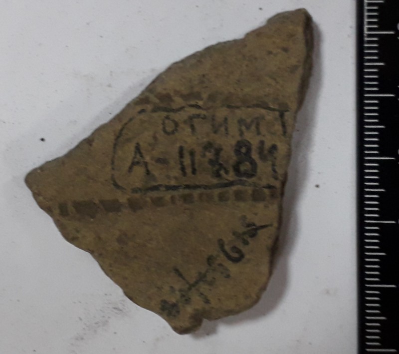 Фрагмент стінки ліпної сіроглиняної посудини, жовтого кольору зовні.