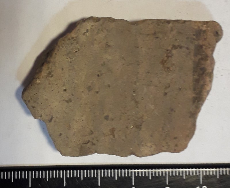 Фрагмент стінки ліпної сіроглиняної посудини, жовтого кольору назовні