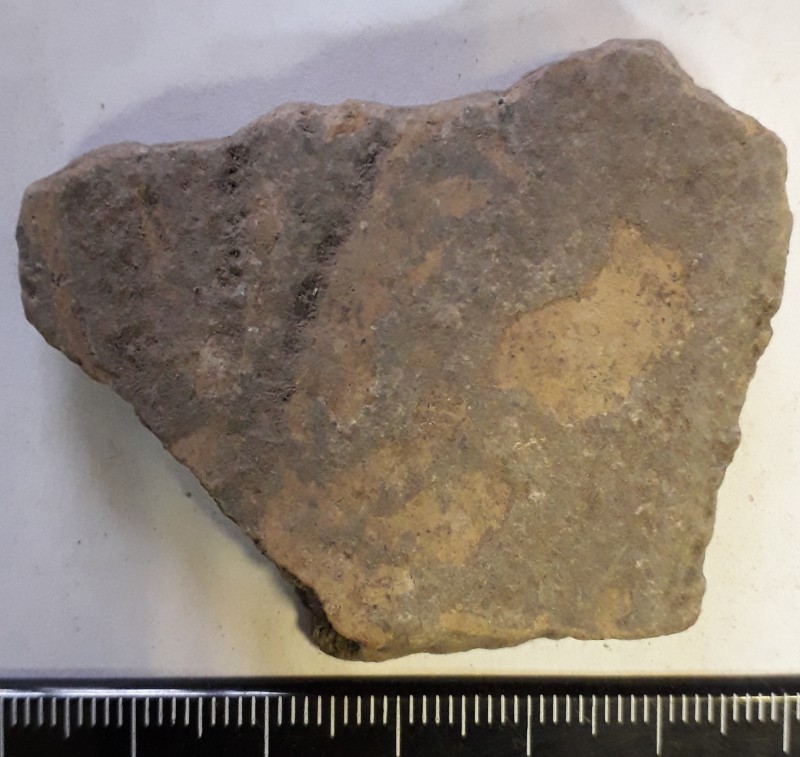 Фрагмент стінки ліпної сіроглиняної посудини, жовтого кольору назовні.