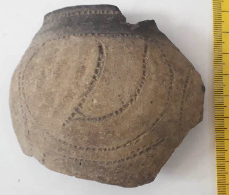Фрагмент стінки ліпної сіроглиняної посудини (кубка) жовтого кольору назовні.