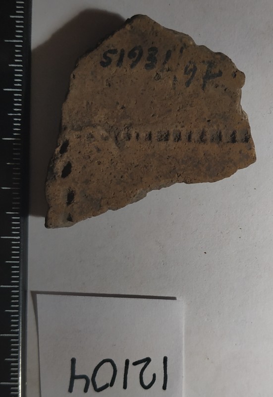 Фрагмент стінки ліпної сіроглиняної посудини жовтого кольору назовні.