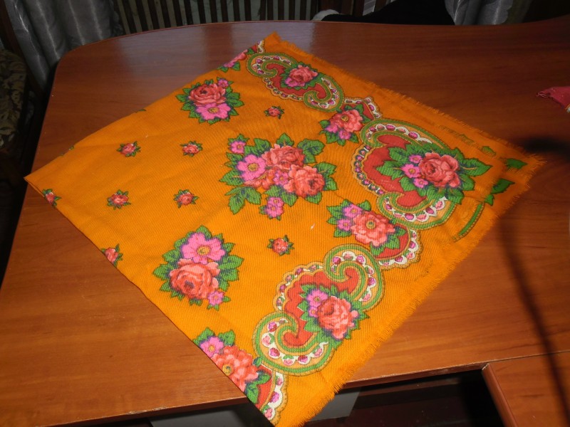 Жіноча хустка помаранчевого кольору з квітковим орнаментом.