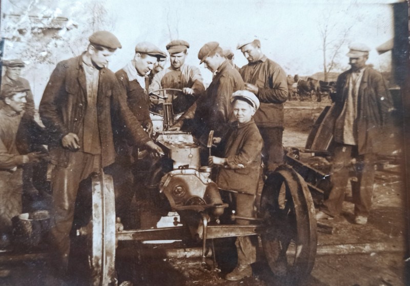Фото, на якому селяни вивчають перший трактор (кінець 1920-х - початок 1930-х років).