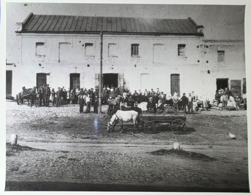 Колектив бобринецького млина по вул. Шевченка 1920 - 30рр. на фото приміщення млина, на його фоні працівники та селяни з пшеницею.